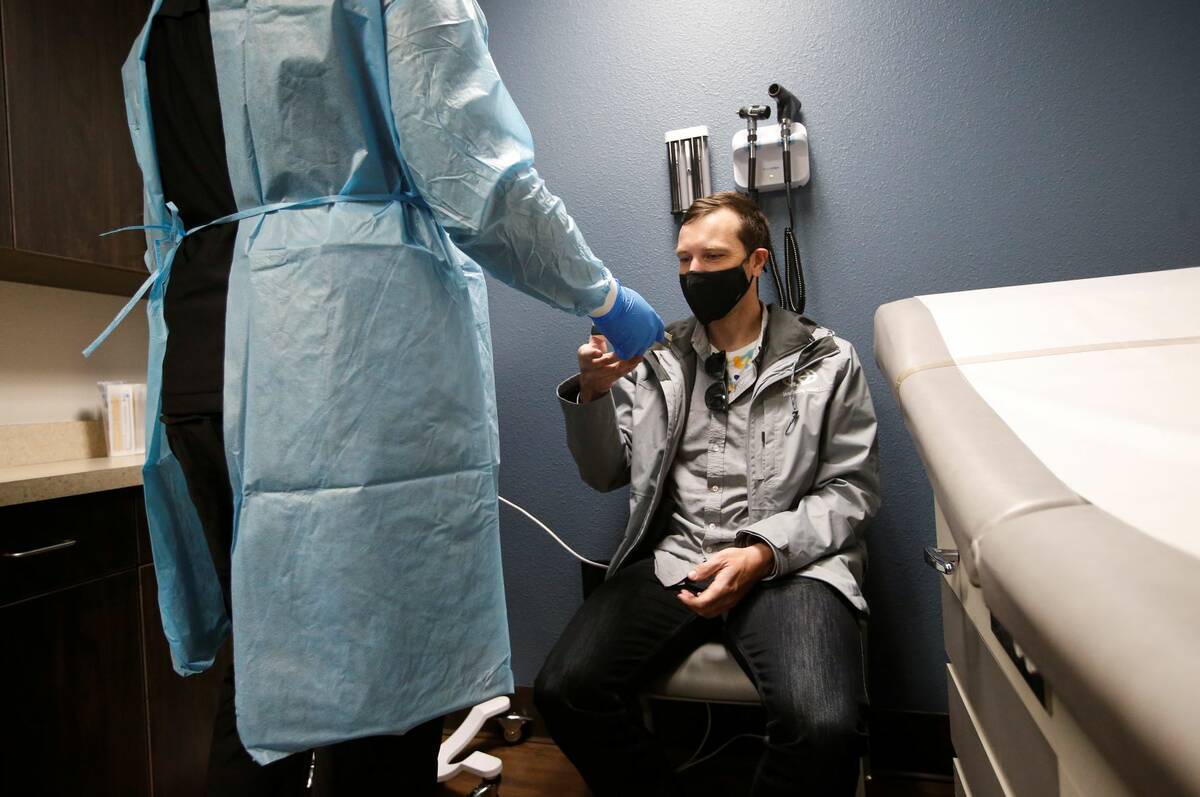 UMC charge nurse Terron Gregory, left, prepares David Hamilton, of Toronto, for a COVID-19 test ...