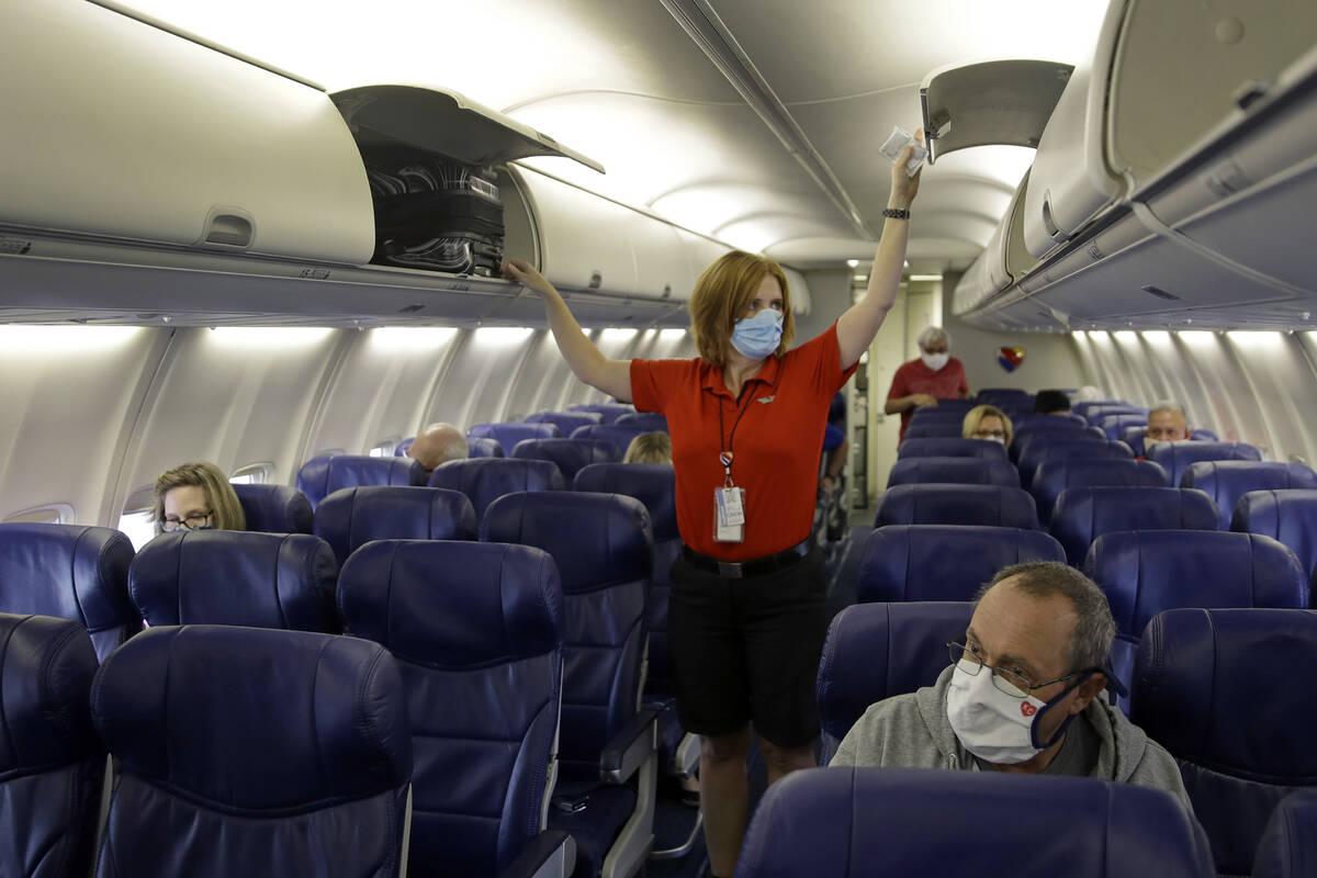 FILE - In this May 24, 2020, file photo, a Southwest Airlines flight attendant prepares a plane ...