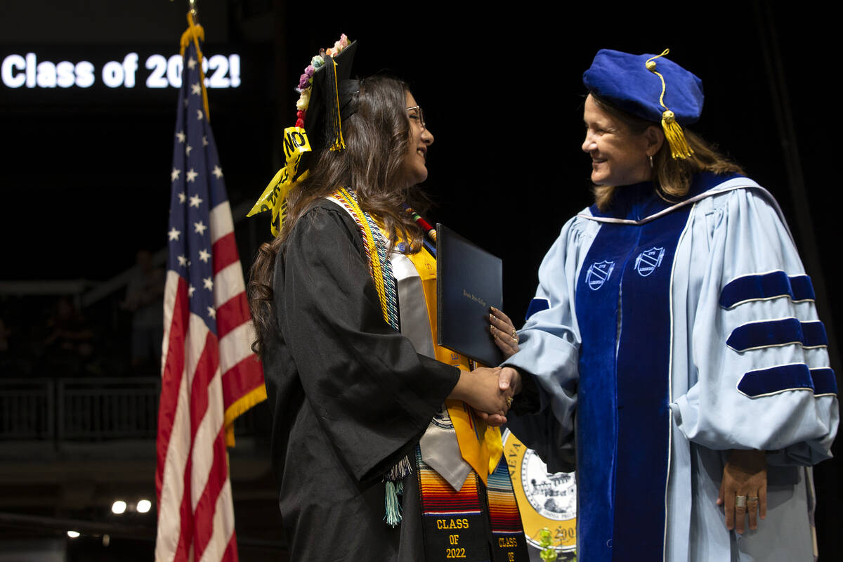 Guetsy Paola Espinoza Guezada, who earned her Bachelor of Science in psychology, shakes the han ...