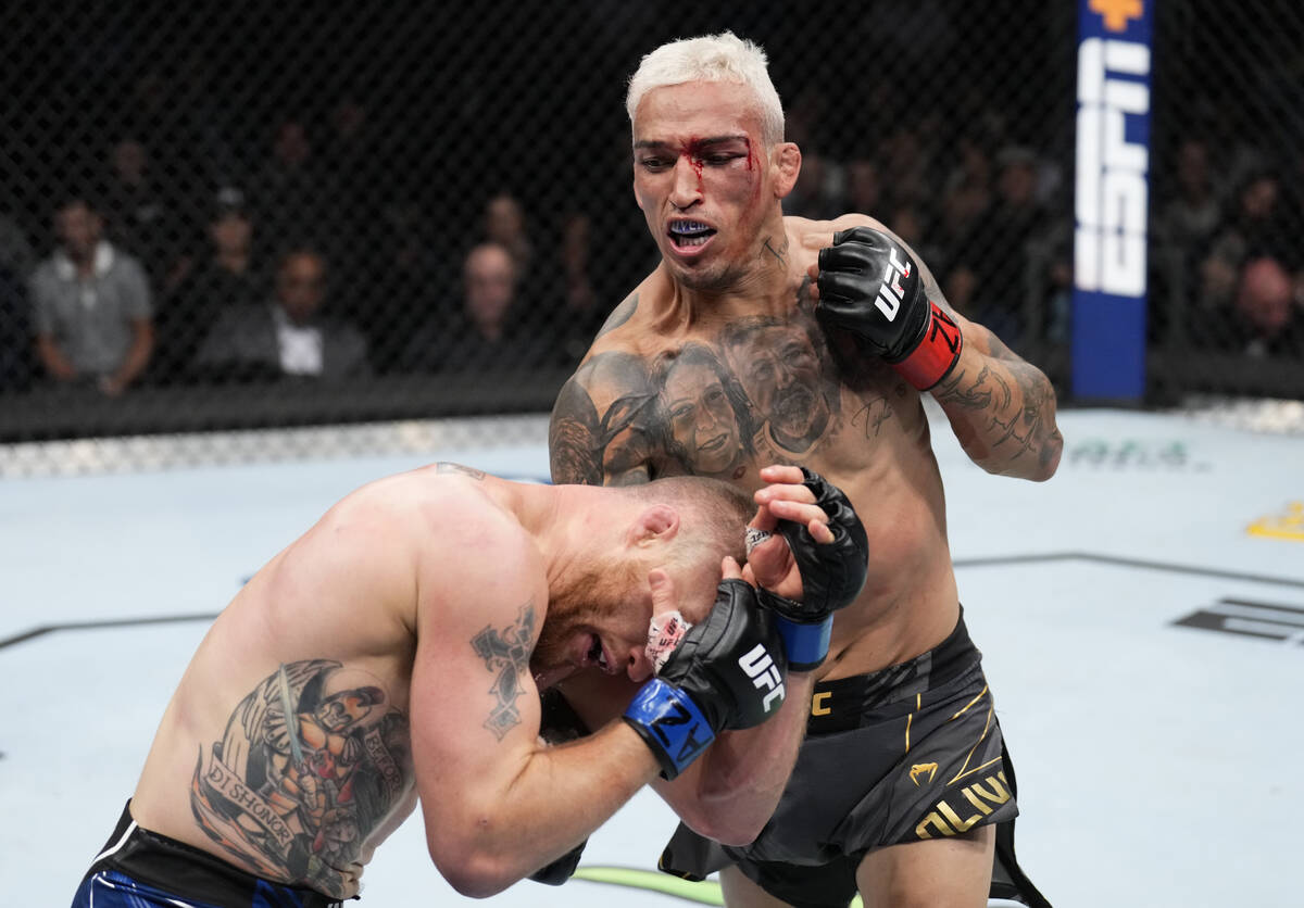 Charles Oliveira of Brazil punches Justin Gaethje in the UFC lightweight championship fight dur ...