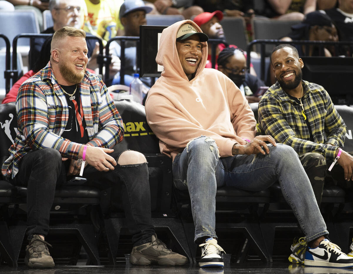 Raiders tight end Darren Waller, middle, takes in the first half of a WNBA basketball game betw ...