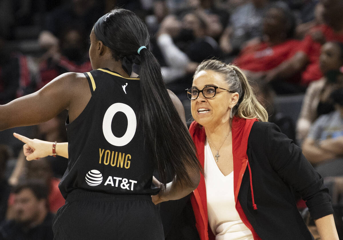 Aces head coach Becky Hammon, right, coaches up Aces guard Jackie Young (0) in the second half ...