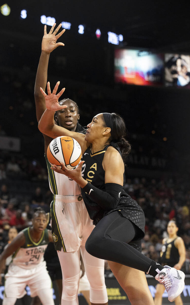 Aces forward A'ja Wilson (22) drives past Seattle Storm center Ezi Magbegor (13) in the first h ...