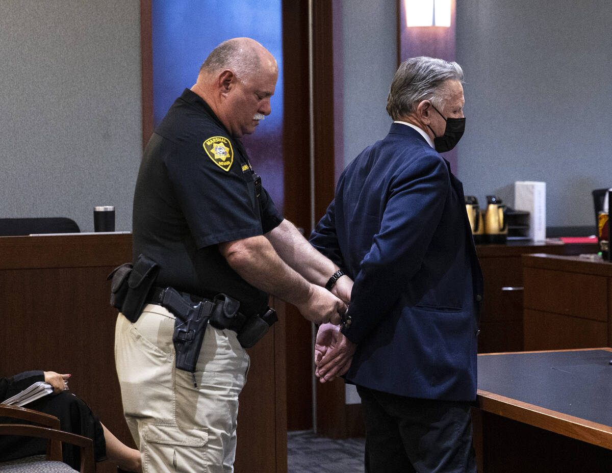 A court officer places handcuffs on Gregory "Brent" Dennis after Dennis’ sentencing at the Re ...