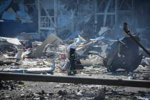 An Ukrainian firefighter works near a destroyed building on the outskirts of Odesa, Ukraine, Tu ...