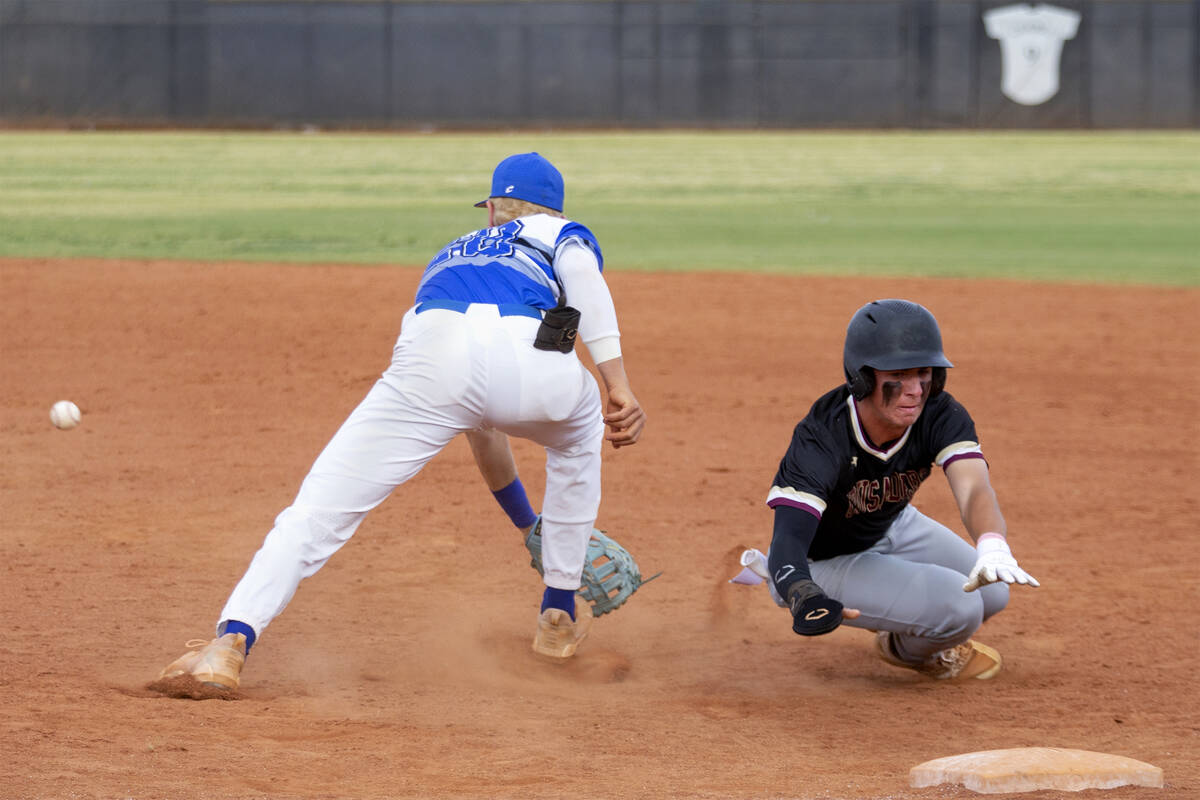 Faith Lutheran’s Caden Richards (2) slides into first base while Basic’s Cooper S ...
