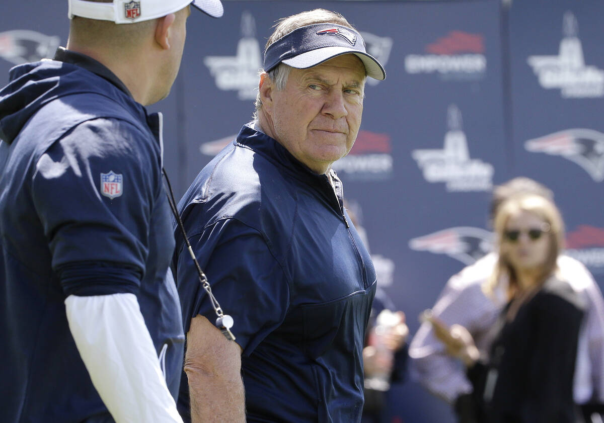 New England Patriots head coach Bill Belichick, center, looks toward offensive coordinator Josh ...