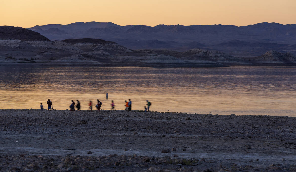 Visitors leave Boulder Beach at dusk as the waterline continues to recede along the shoreline o ...