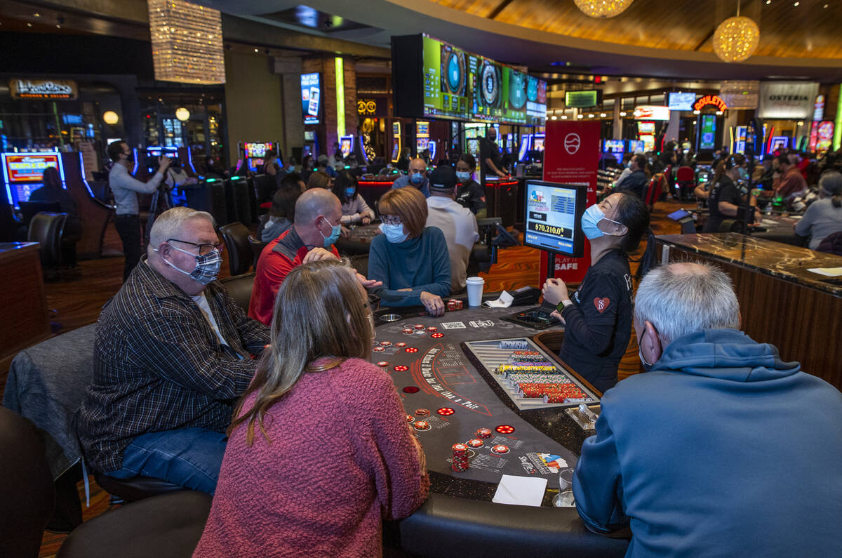 A dealer reacts to a winning hand as guests play Ultimate Texas Hold’Em at Red Rock Casi ...