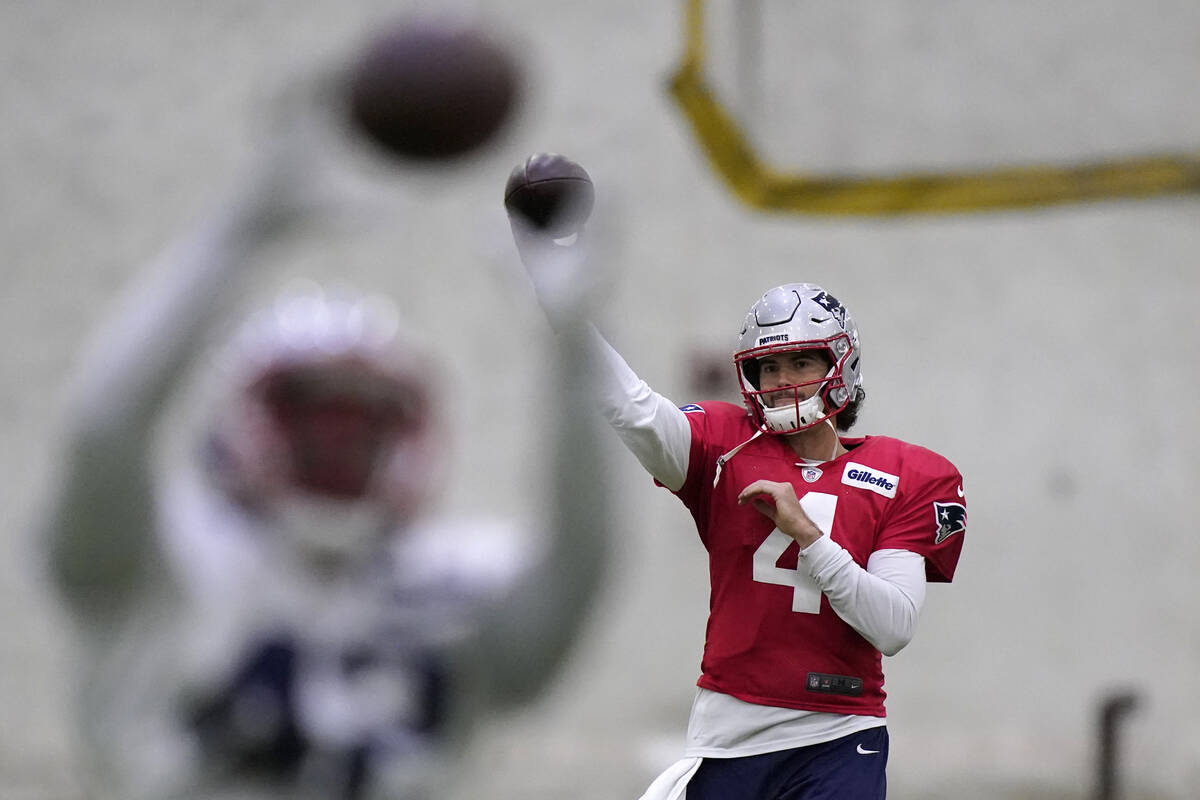 New England Patriots quarterback Jarrett Stidham (4) passes as running back J.J. Taylor, left, ...
