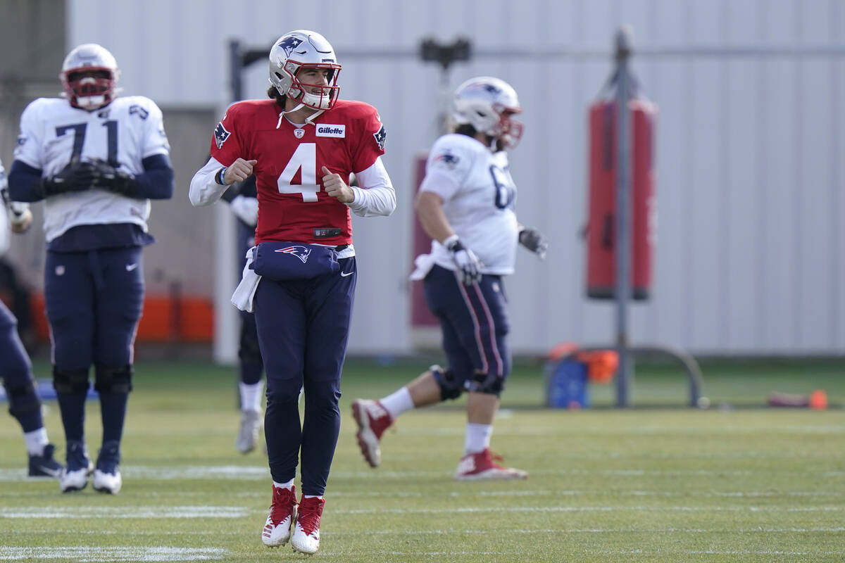 New England Patriots quarterback Jarrett Stidham (4) warms up with teammates during an NFL foot ...