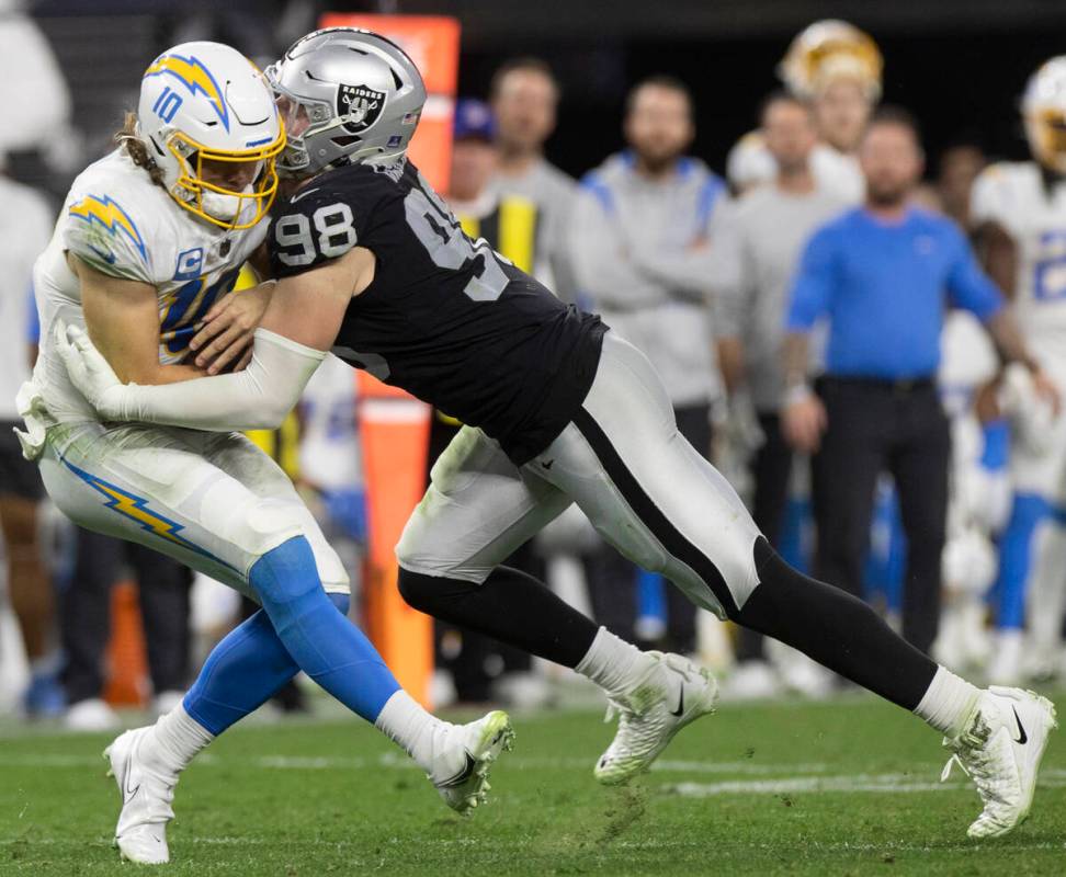 Raiders defensive end Maxx Crosby (98) sacks Los Angeles Chargers quarterback Justin Herbert (1 ...