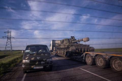 A truck transports a platform with a Ukrainian self-propelled artillery vehicle in Donetsk regi ...
