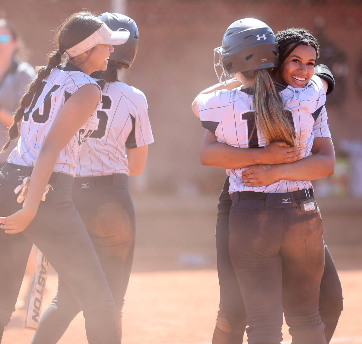 Faith Lutheran players, including Ava Walker (2), right and McKenna Young (19), celebrate beati ...