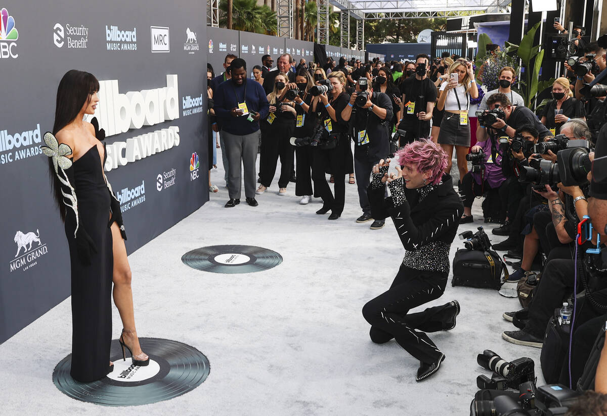 Megan Fox, left, poses as Machine Gun Kelly mimics photographers on the red carpet for the Bill ...