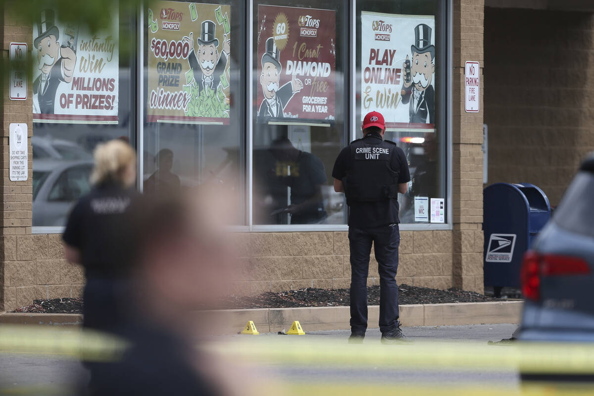 Police investigate after a shooting at a supermarket, Saturday, May 14, 2022, in Buffalo, N.Y. ...