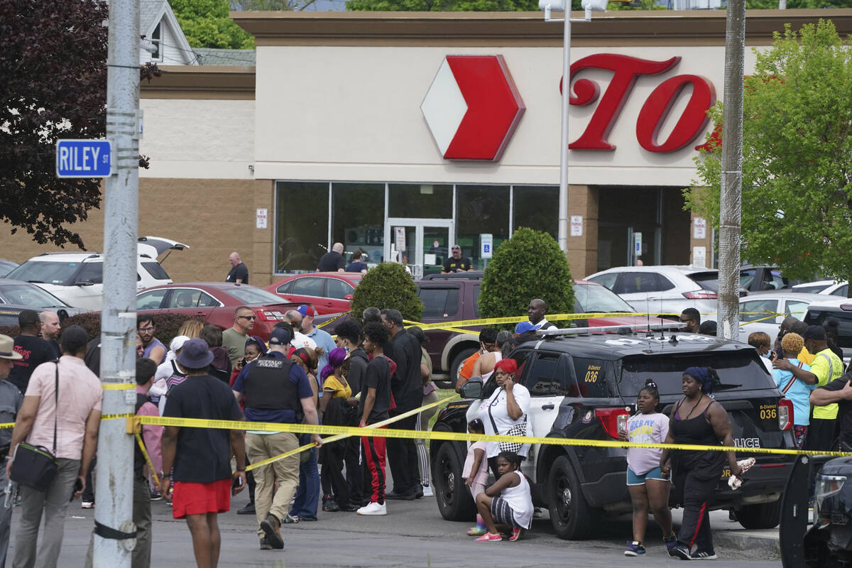 People gather outside a supermarket where several people were killed in a shooting, Saturday, M ...