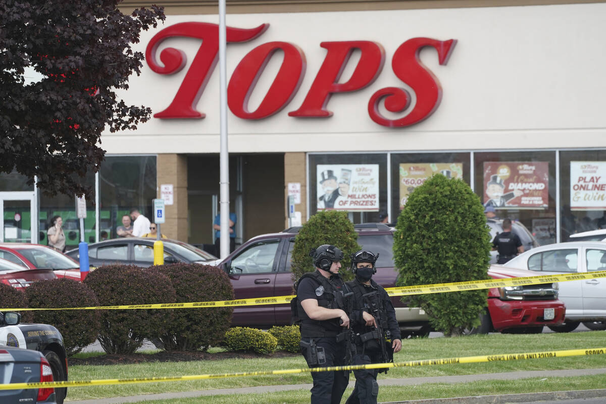 Police secure an area around a supermarket where several people were killed in a shooting, Satu ...
