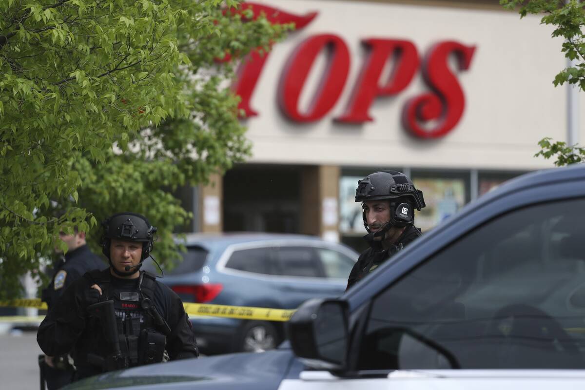 Police secure a perimeter after a shooting at a supermarket, Saturday, May 14, 2022, in Buffalo ...