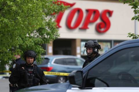 Police secure a perimeter after a shooting at a supermarket, Saturday, May 14, 2022, in Buffalo ...