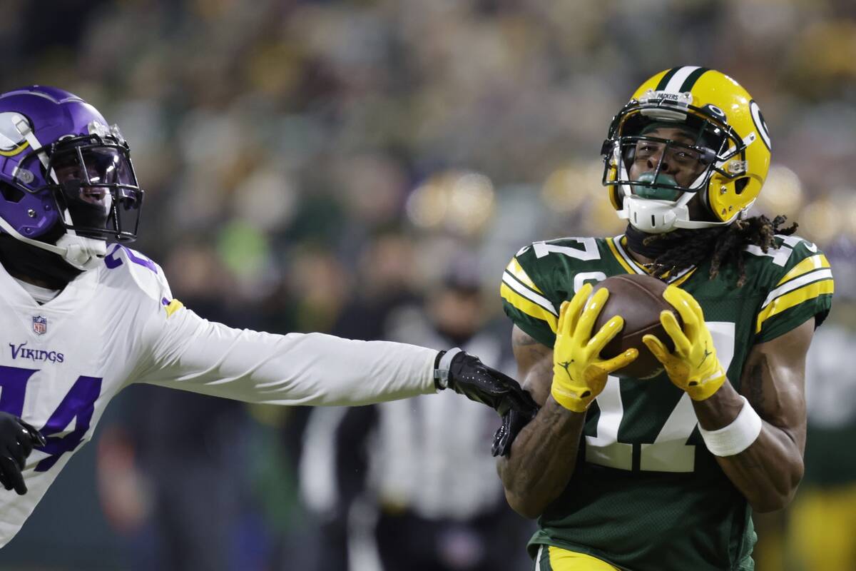 Green Bay Packers' Davante Adams catches a pass in front of Minnesota Vikings' Mackensie Alexan ...