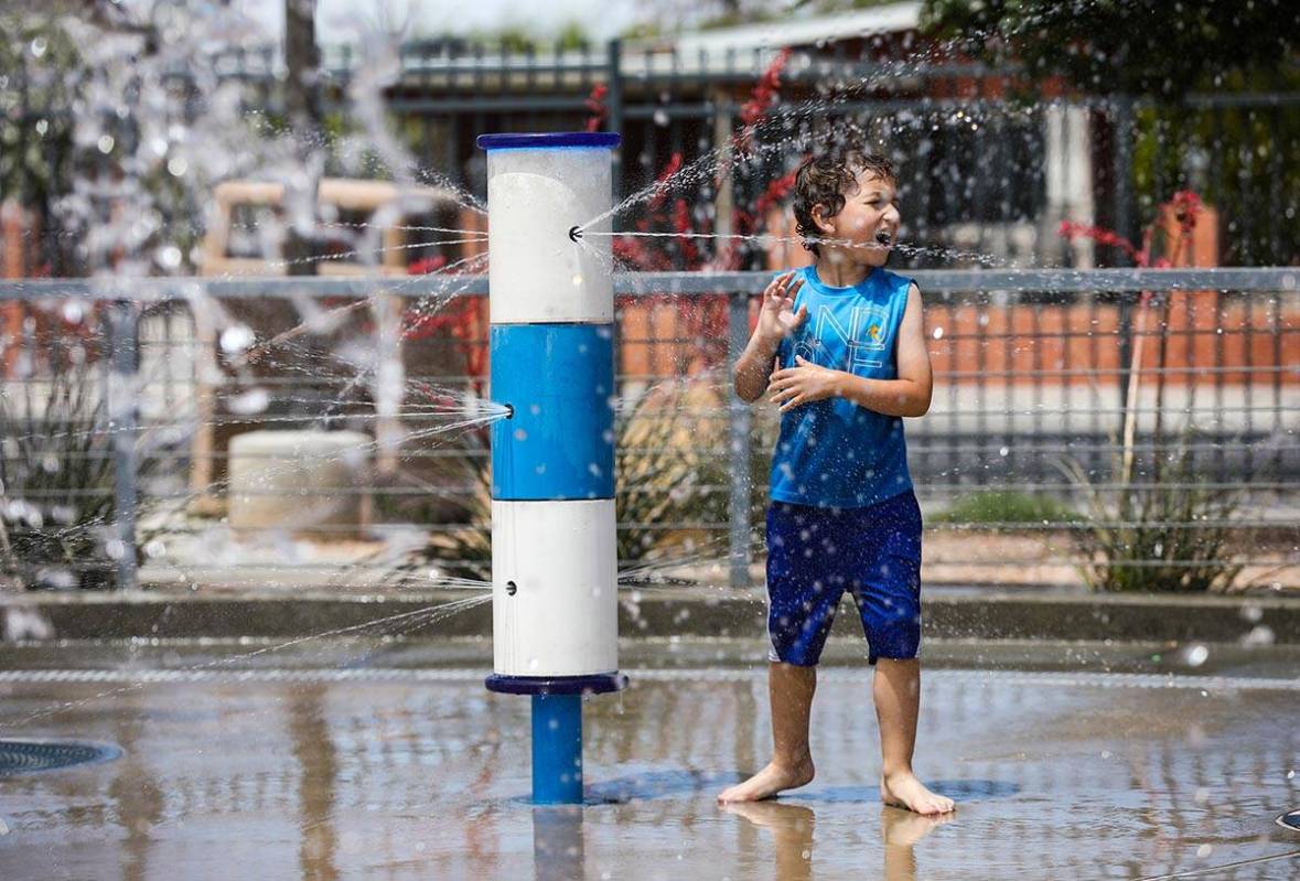 K.J. Lefear-Bleything, 5, plays with the water features at Baker Park in Las Vegas, Sunday, May ...