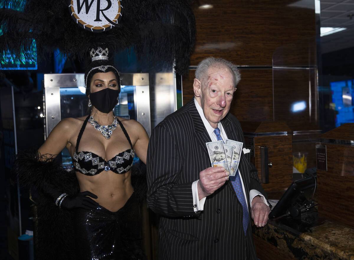 Former Las Vegas Mayor Oscar Goodman flashes dollar bills as he places his March Madness wager ...