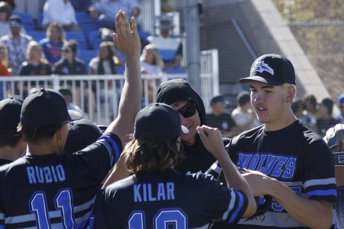 Basic pitcher Ben Smith, right, high-fives teammates at the end of the forth inning of a baseba ...