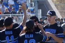 Basic pitcher Ben Smith, right, high-fives teammates at the end of the forth inning of a baseba ...