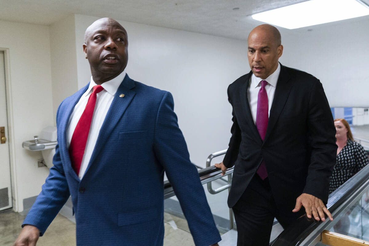 FILE - Sen. Tim Scott, R-S.C., left, and Sen. Cory Booker, D-N.J. talk as they walk from the Se ...