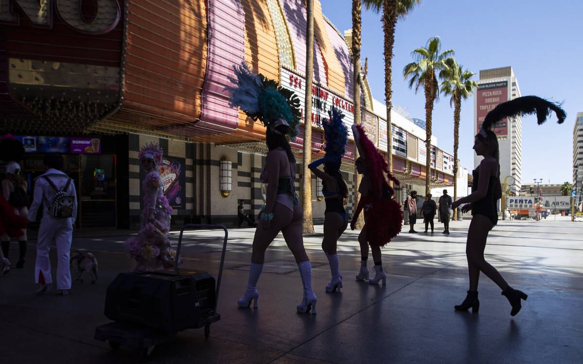 Participants in the Las Vegas Showgirl parade walk along the Fremont Street Experience on Sunda ...