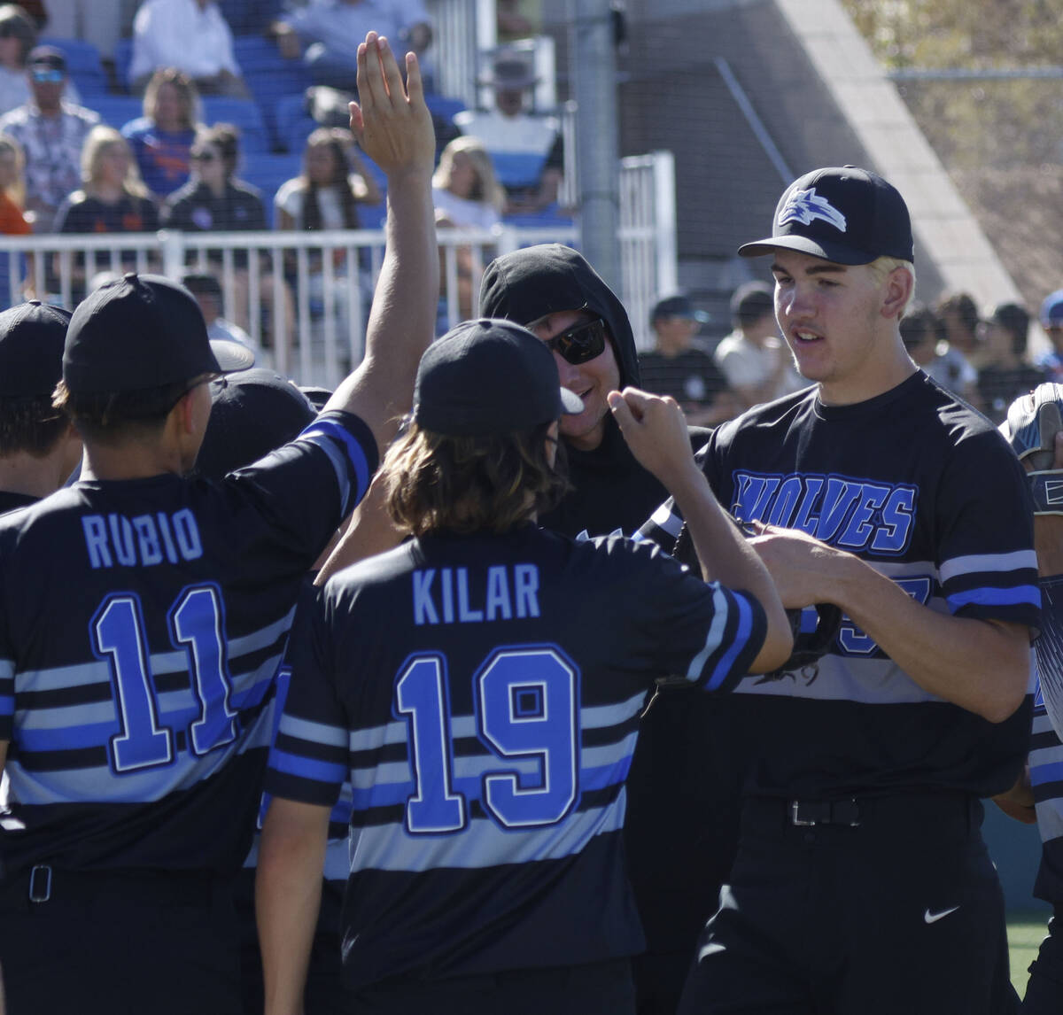 Basic pitcher Ben Smith, right, high-fives teammates at the end of the forth inning of a baseba ...