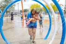 Stephanie Ramirez holds her daughter Raylee Brown, 2, as they play in the water at Baker Park i ...