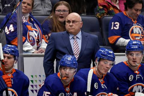 New York Islanders head coach Barry Trotz, center, looks on in the first period of an NHL hocke ...