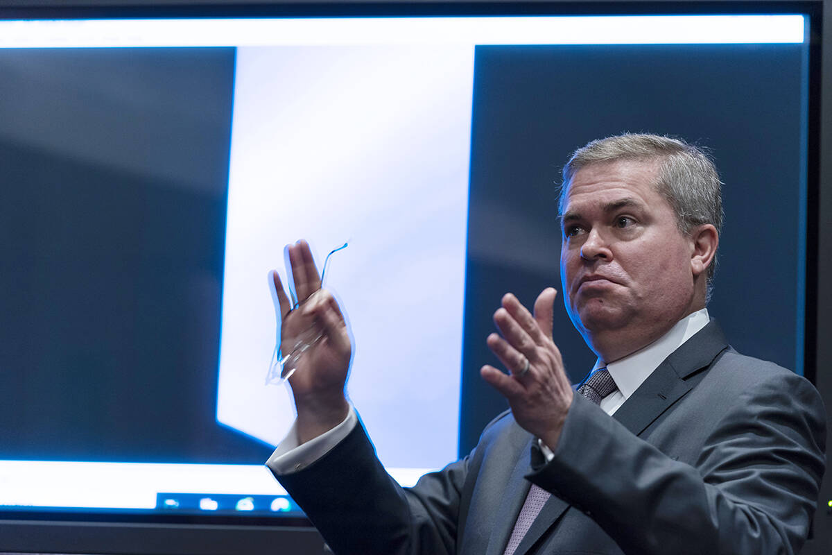 Deputy Director of Naval Intelligence Scott Bray speaks in front of a video display of a UAP du ...