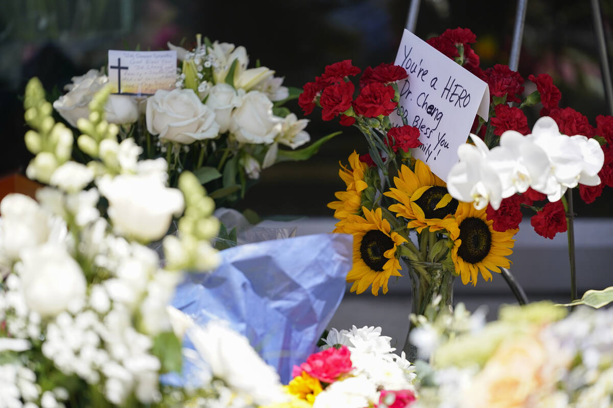 Flowers and cards are among a memorial honoring Dr. John Cheng outside his office building on T ...