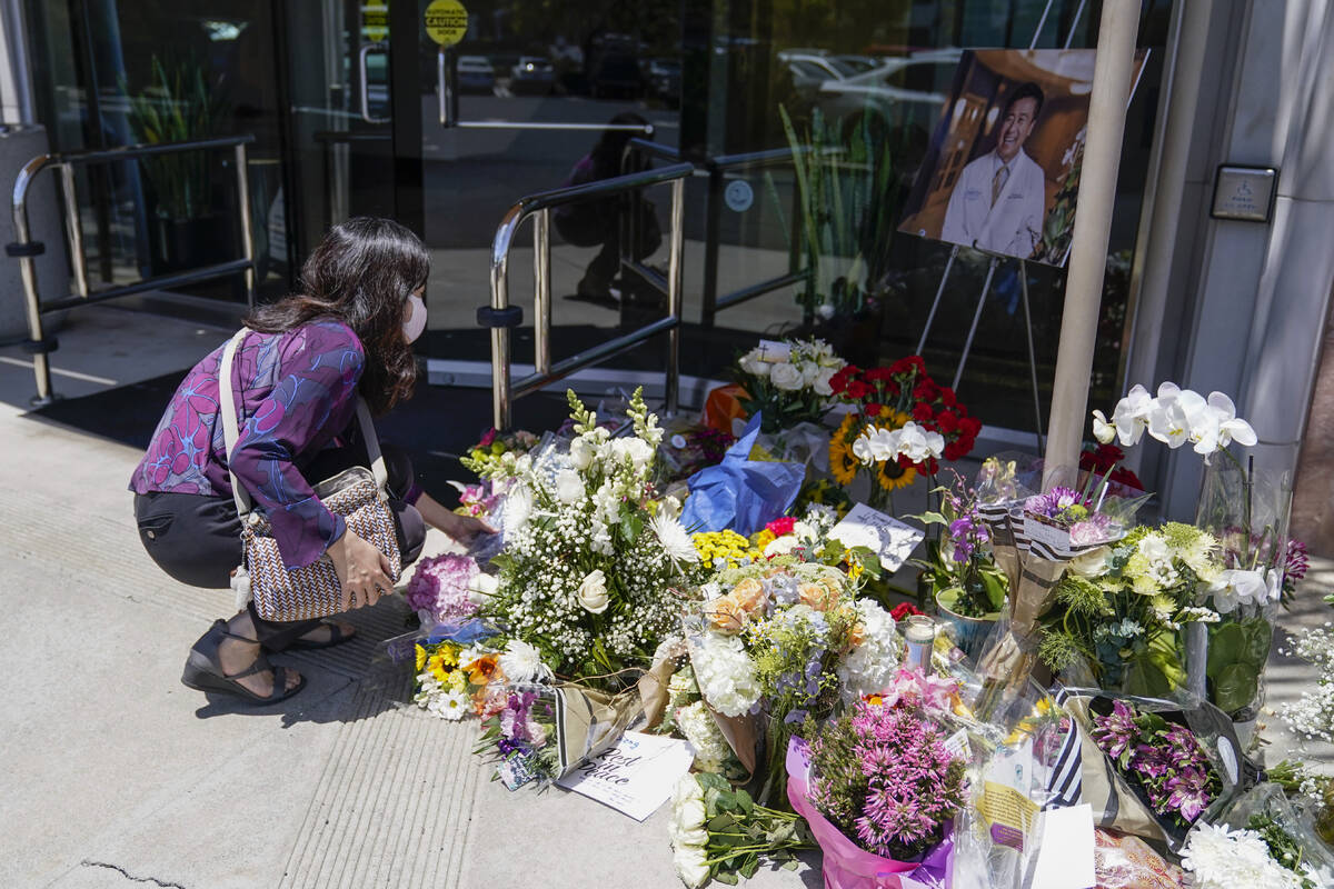 Grace Hung, a patient of Dr. John Cheng, places flowers at a memorial honoring him outside his ...