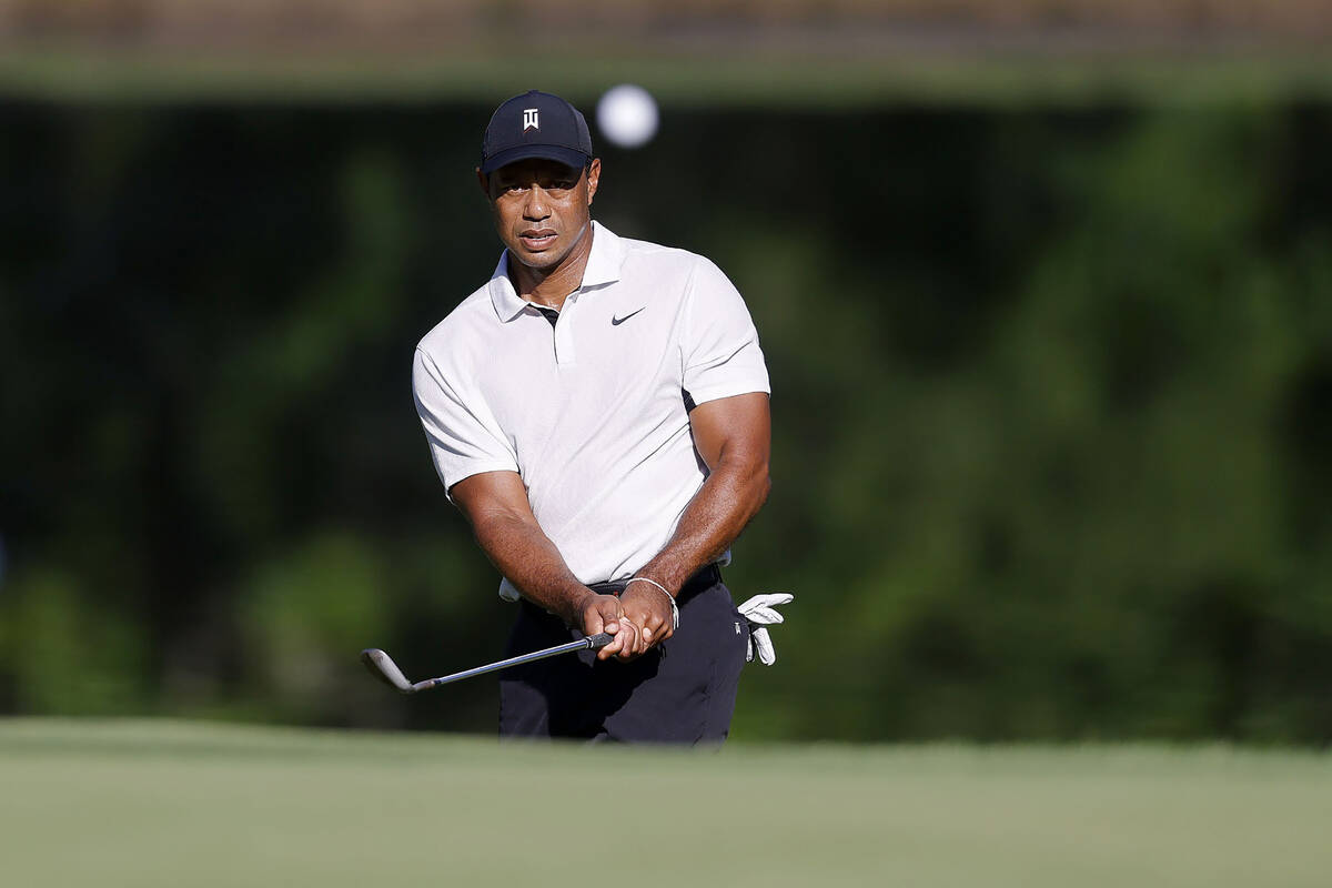 Tiger Woods hits a chip shot on the 11th hole during a practice round for the PGA Championship ...