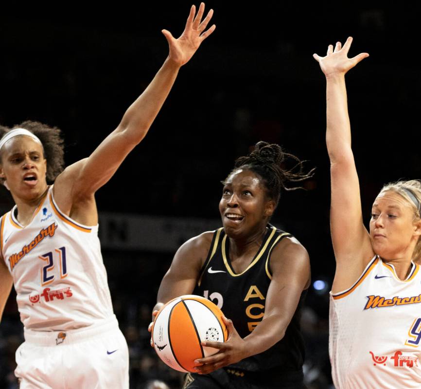Aces guard Chelsea Gray (12) splits Phoenix Mercury forward Brianna Turner (21) and Phoenix Mer ...