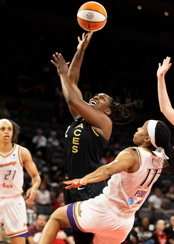Aces guard Chelsea Gray (12) scores plus the foul over Phoenix Mercury guard Shey Peddy (11) in ...