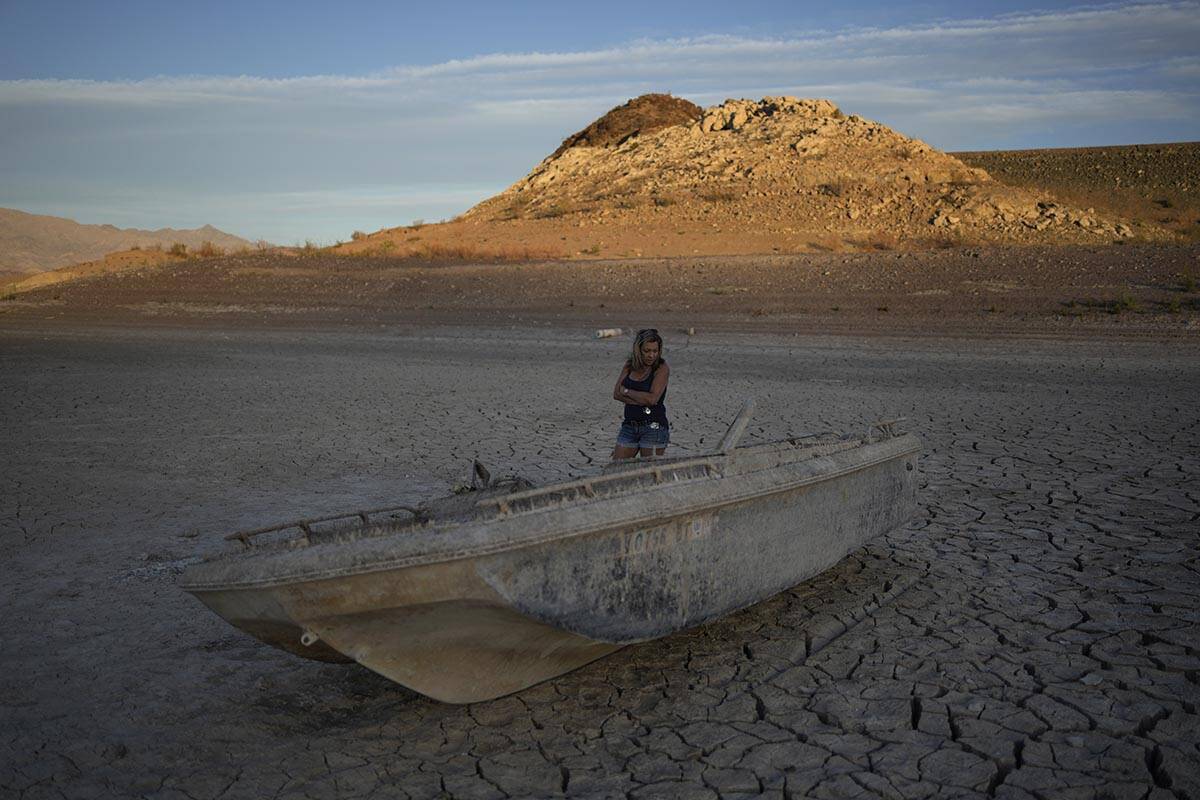 Misha McBride looks at a formerly sunken boat now on cracked earth hundreds of feet from what i ...