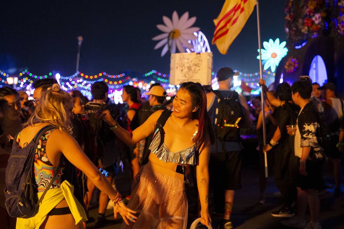 Attendees dance underneath the glow of the fire rings during the first day of the Electric Dais ...