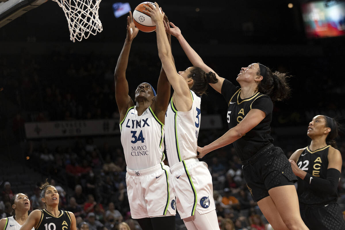 Las Vegas Aces forward Dearica Hamby (5) attempts to thwart a shot by Minnesota Lynx center Syl ...