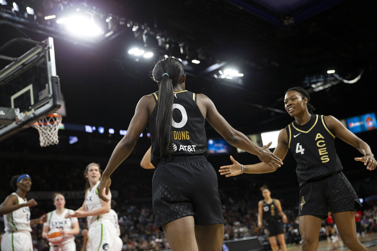 Las Vegas Aces guard Jackie Young (0) slaps hands with guard Aisha Sheppard (4) during the seco ...