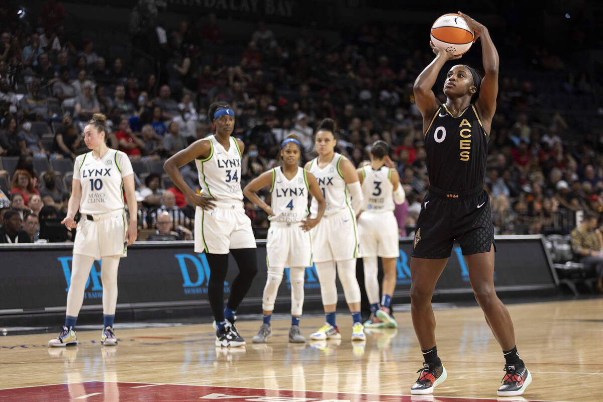 Las Vegas Aces guard Jackie Young (0) shoots a free throw while Minnesota Lynx players look on ...