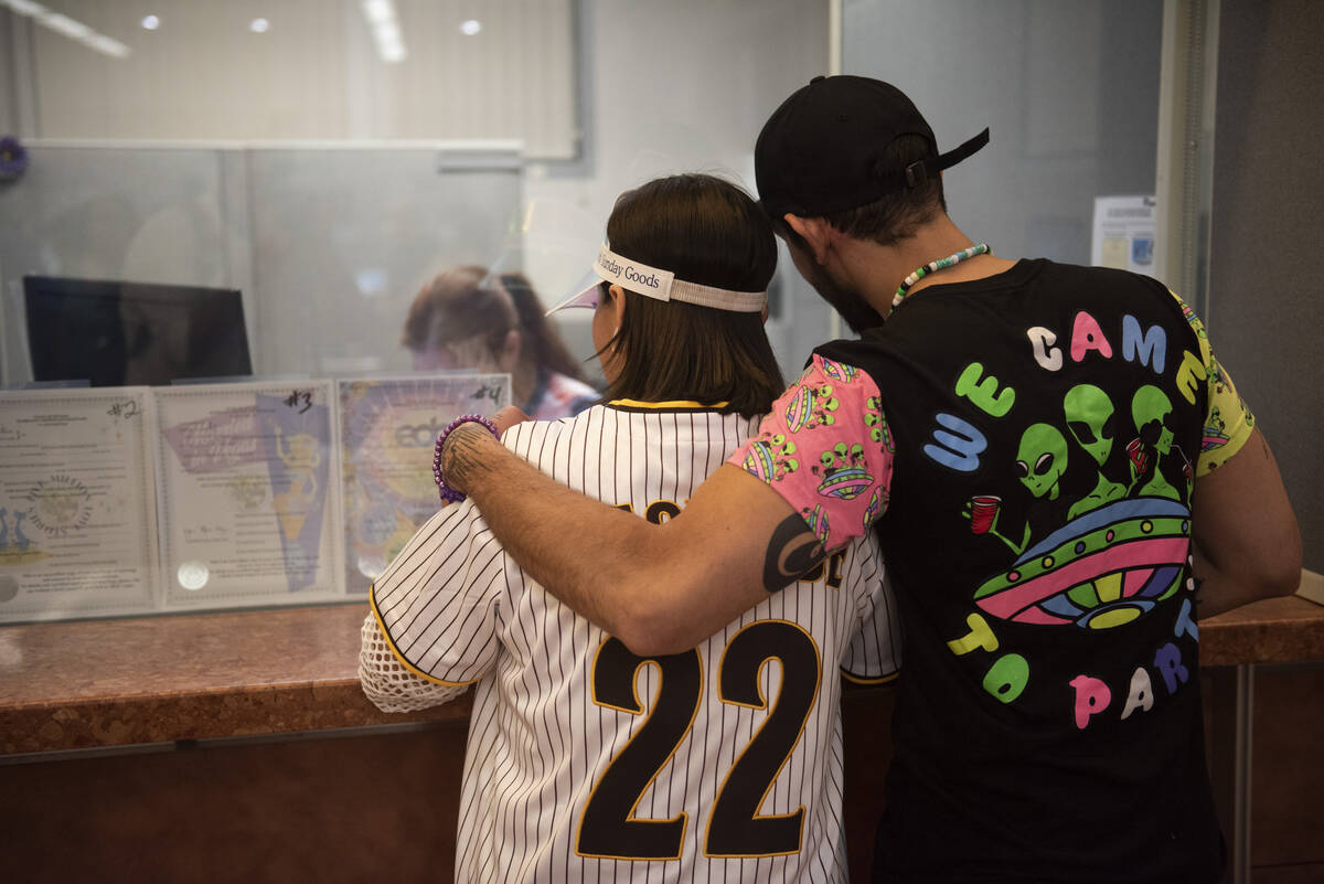 Jessica Avila, left, and Carlos Mendez get their EDC-themed marriage license at the Clark Count ...