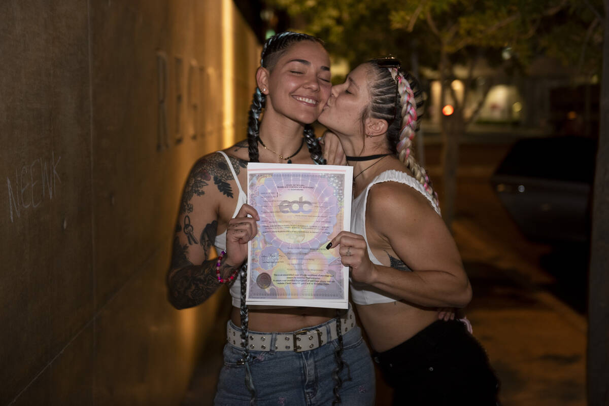 Alix Washington, left, and Cyndel Magalhaes pose with their EDC-themed marriage license at the ...