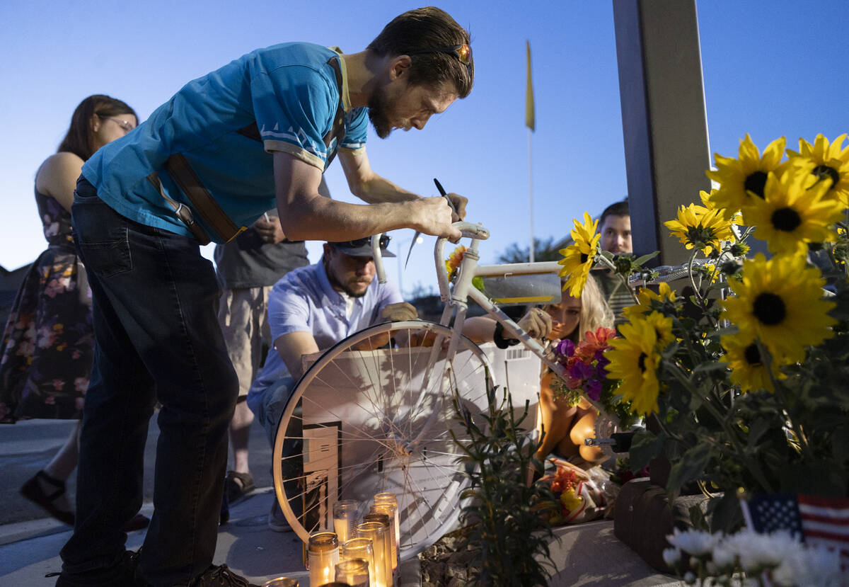 Attendees sign a bike during a memorial for Ben Black, 31, the bicyclist killed last Sunday in ...