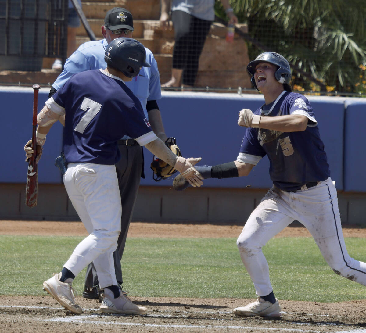 Shadow Ridge's Ty Silva (5) receive a high-five from his teammate Evan Harnum (7) after scoring ...