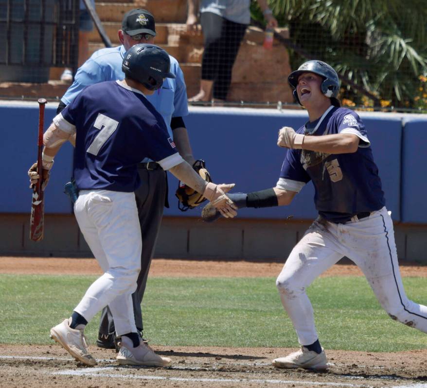 Shadow Ridge's Ty Silva (5) receive a high-five from his teammate Evan Harnum (7) after scoring ...
